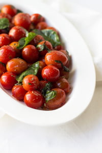 A top-down view of herb-roasted tomatoes served as a side dish