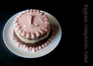 Top view of an Eggless Neapolitan Cake with smooth frosting and garnishes