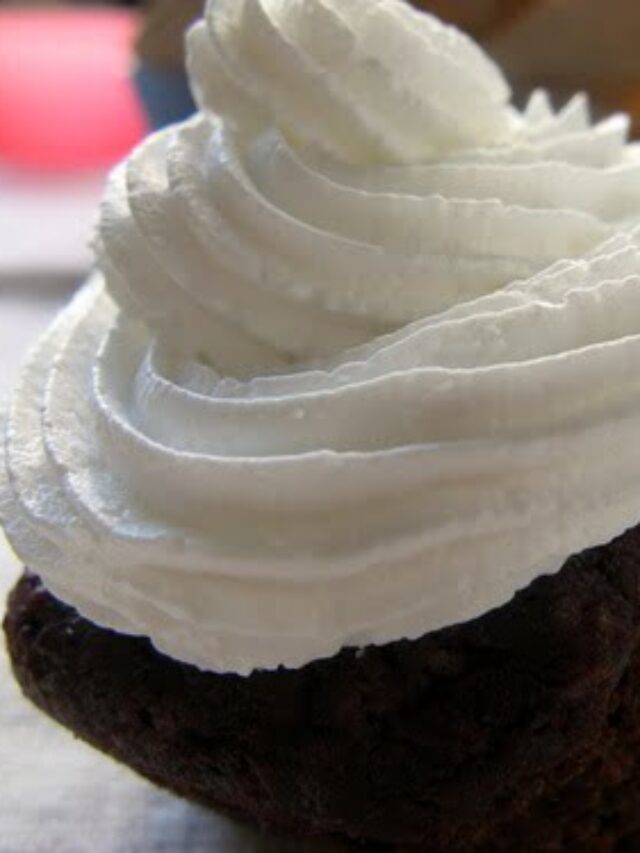 Single red velvet cupcake with cream cheese swirl and sprinkles.