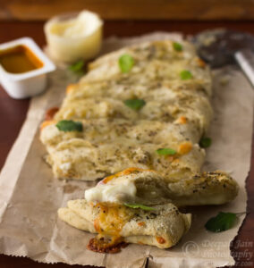 Freshly baked homemade cheesy breadsticks on a baking tray