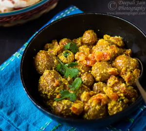 A delicious serving of Bengali Style Dry Dum Aloo (Bengali Aloo Dum) garnished with fresh coriander on a white plate