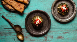 Close-up shot of Palak Paneer Bhurji served in a bowl with garnished with chopped tomatoes