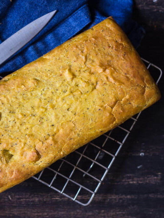 A loaf of No-Knead Masala Bread on a wire rack, with a knife