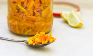 Jar of Kachi Haldi ka Achar placed with a spoon and a slice of lemon