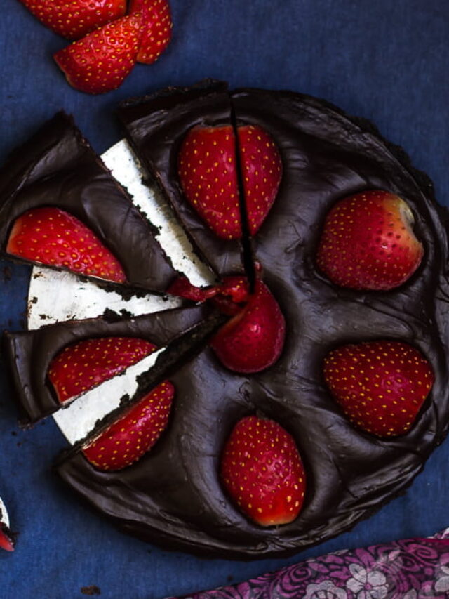 Close-up of a slice of no-bake chocolate strawberry tart with fresh strawberries on top