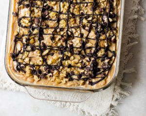 Whole mocha tres leches cake topped with whipped cream and cocoa