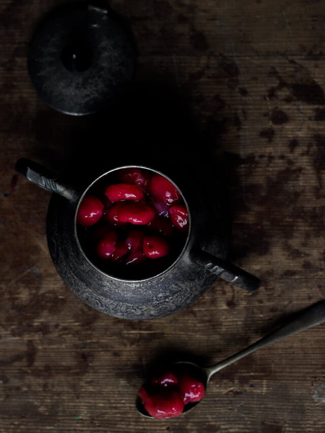 Overhead view of cherry compote in a glass container