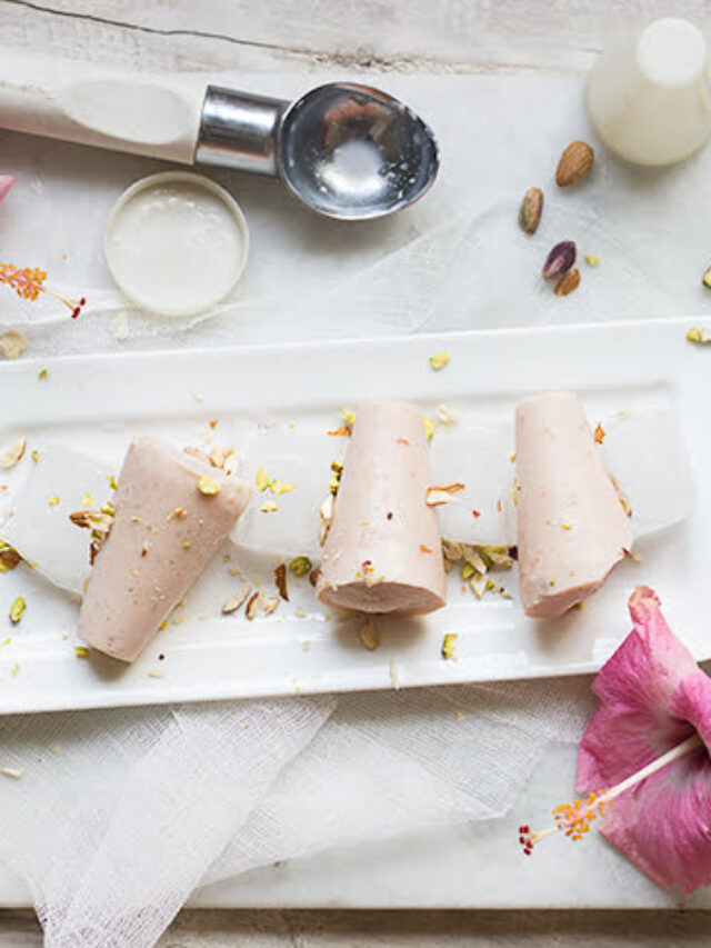 A close-up of a creamy Strawberry Malai Kulfi on a stick