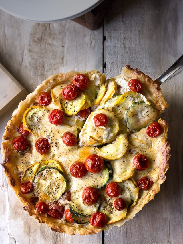 Freshly baked Tomato Zucchini Tart with golden crust and vibrant vegetable topping