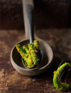 A close-up shot of vibrant green chilli pickle showcasing its spicy and tangy texture