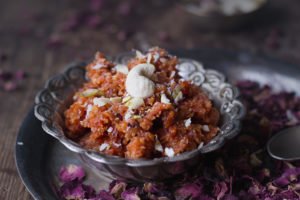 A bowl of Gajar ka Halwa garnished with chopped nuts, ready to be enjoyed