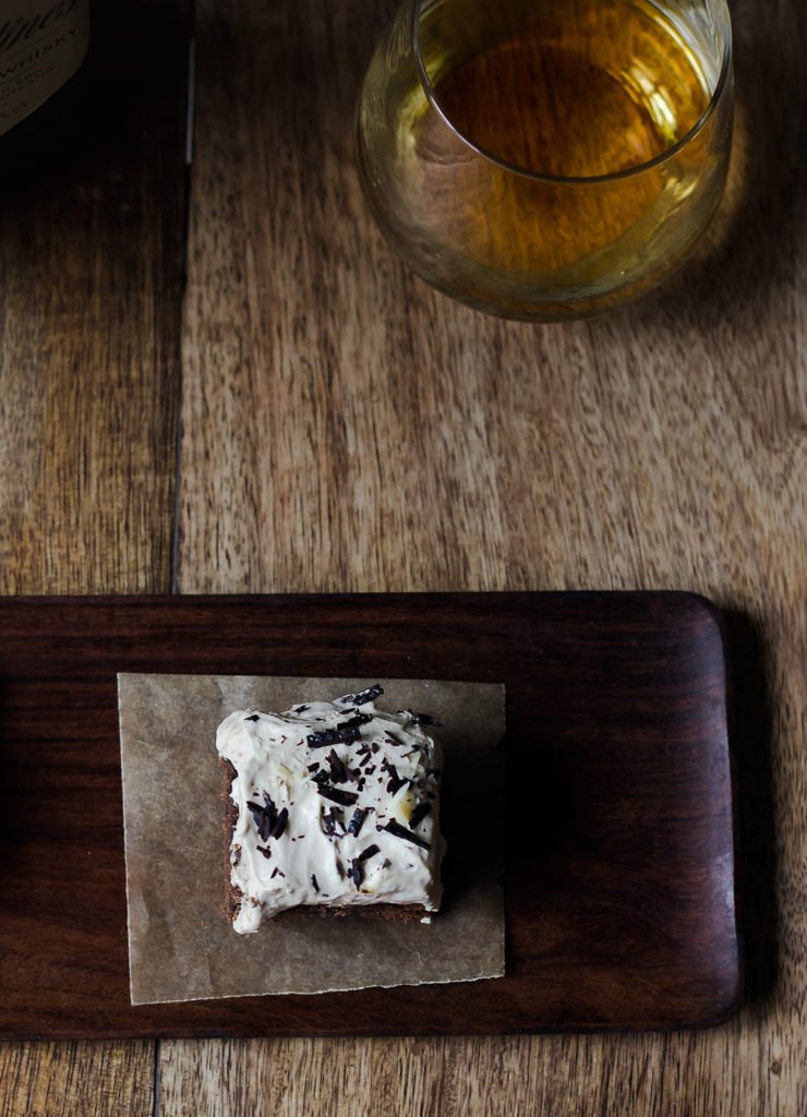 A slice of Eggless Whiskey Coffee Poke Cake garnished with the grated chocolate