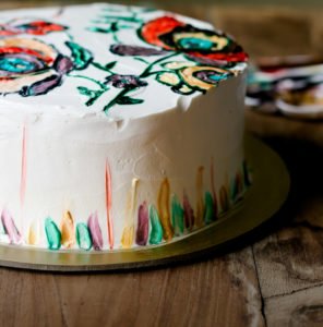 Moist and fluffy eggless hand-painted cake on a plate, highlighting the rich texture and detailed artwork