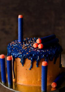 Detailed close-up of an Eggless Nerf Gun Cake showcasing nerf bullets and vibrant colors