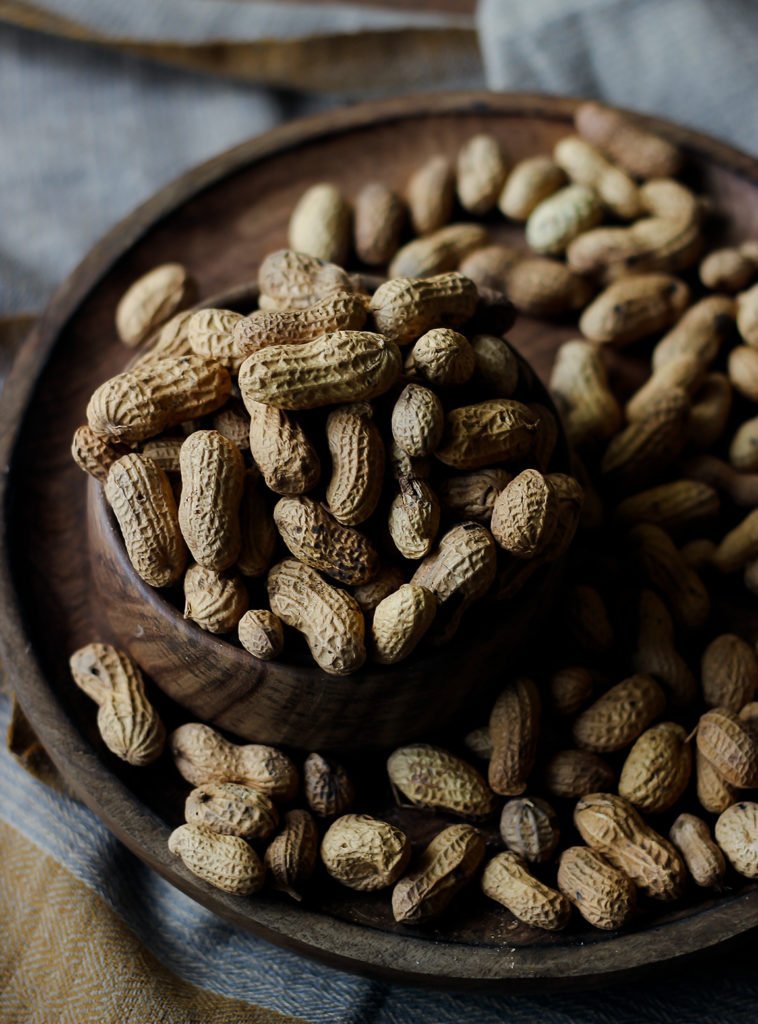 A bowl full of peanuts that's enriched in protein