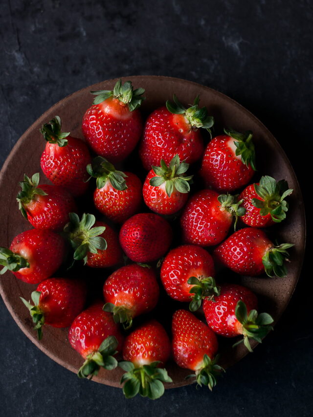 Close-up of fresh, ripe strawberries with vibrant red color and green leaves