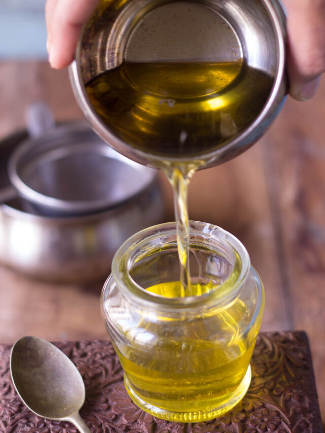 Poring homemade ghee to jar from a bowl