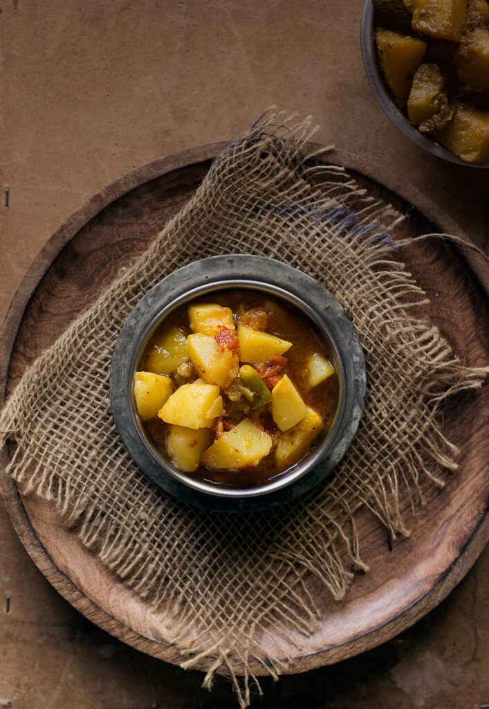 Close-up of tender potato chunks in a rich tomato gravy