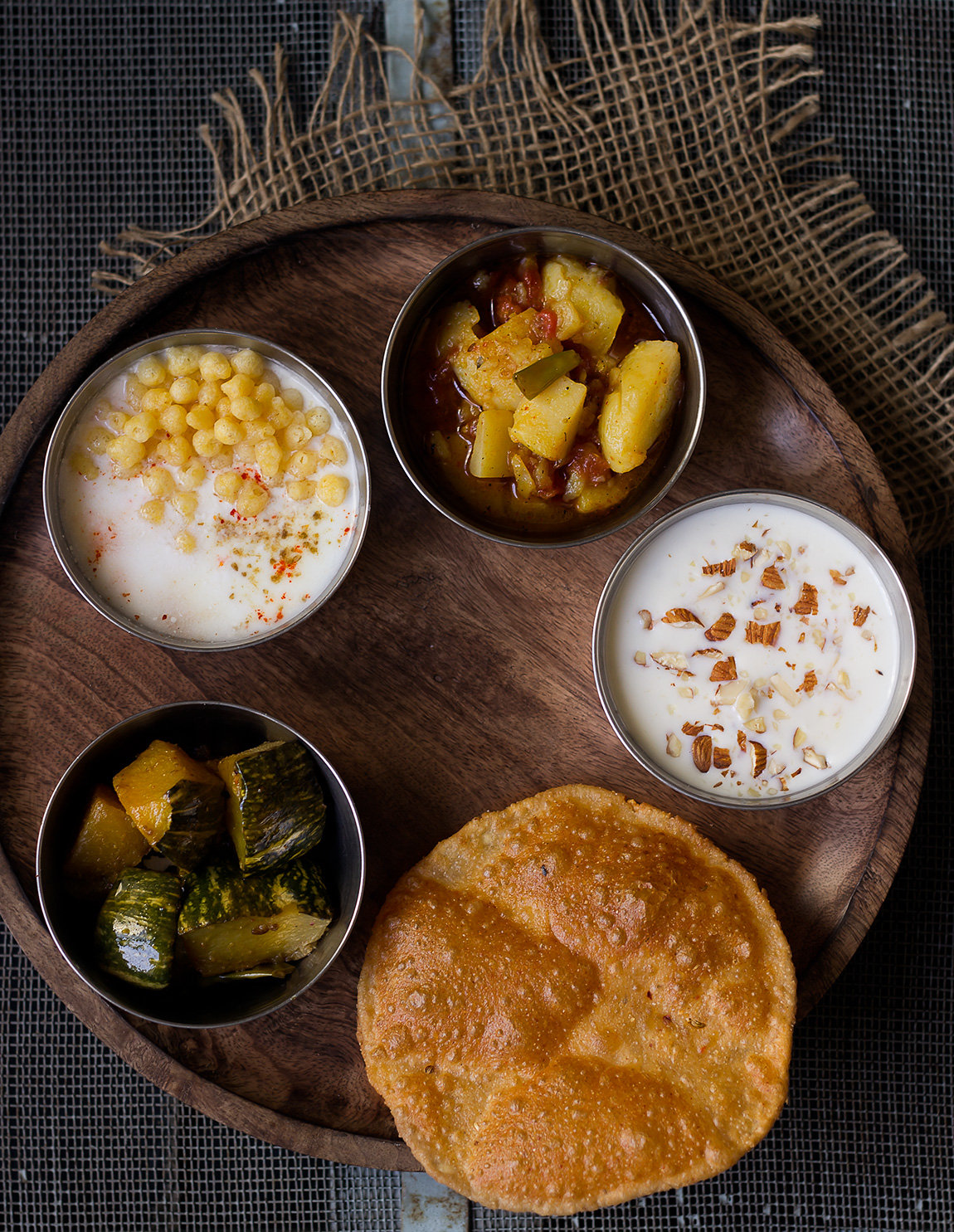 A beautifully arranged Satvik Thali featuring a variety of vegetarian dishes, served on a traditional wooden platter