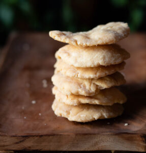 Close-up of a stack of golden-brown crispy Mathri with visible flaky layers