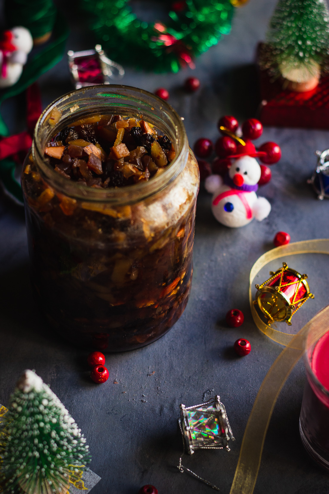 Close-up of dried fruits and nuts soaking in a glass jar for a rich Christmas cake