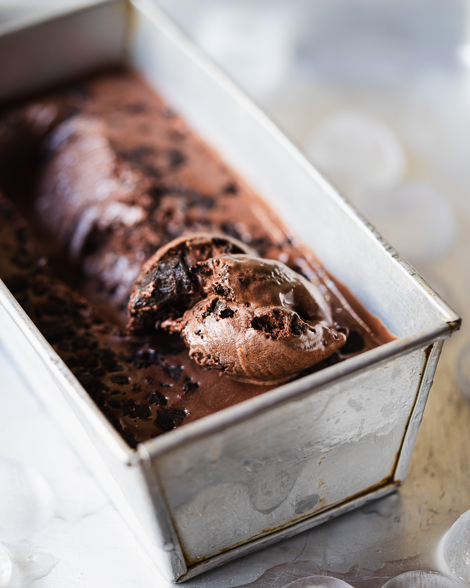 Scoops of chocolate ice cream garnished with chocolate sauce and nuts